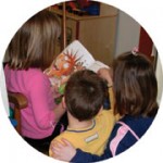 Three children looking at a book.