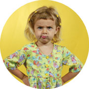 Young girl with hands on hips, pouting.