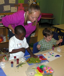 Teachers watching children during an art project.