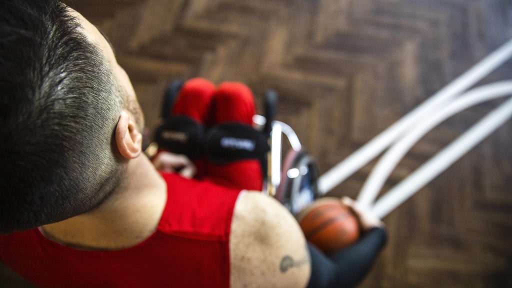 Man in a wheelchair playing basketball.