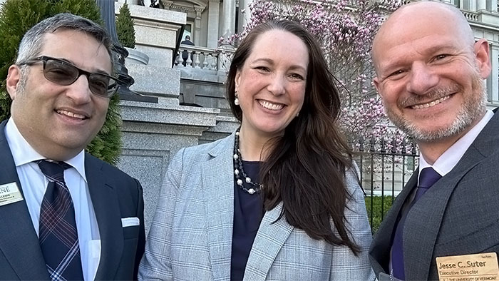 Three people, a man, a woman and another man, standing in front of the Eisenhower Executive Office Building in Washington, DC.